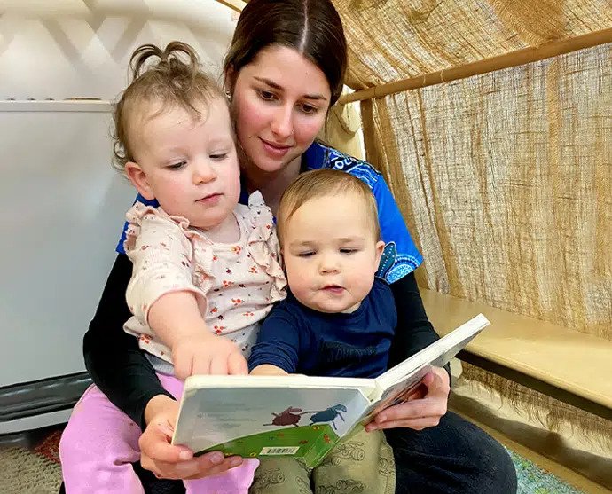 Woman Showing Books To Toddler — Early Learning in Highfields, QLD